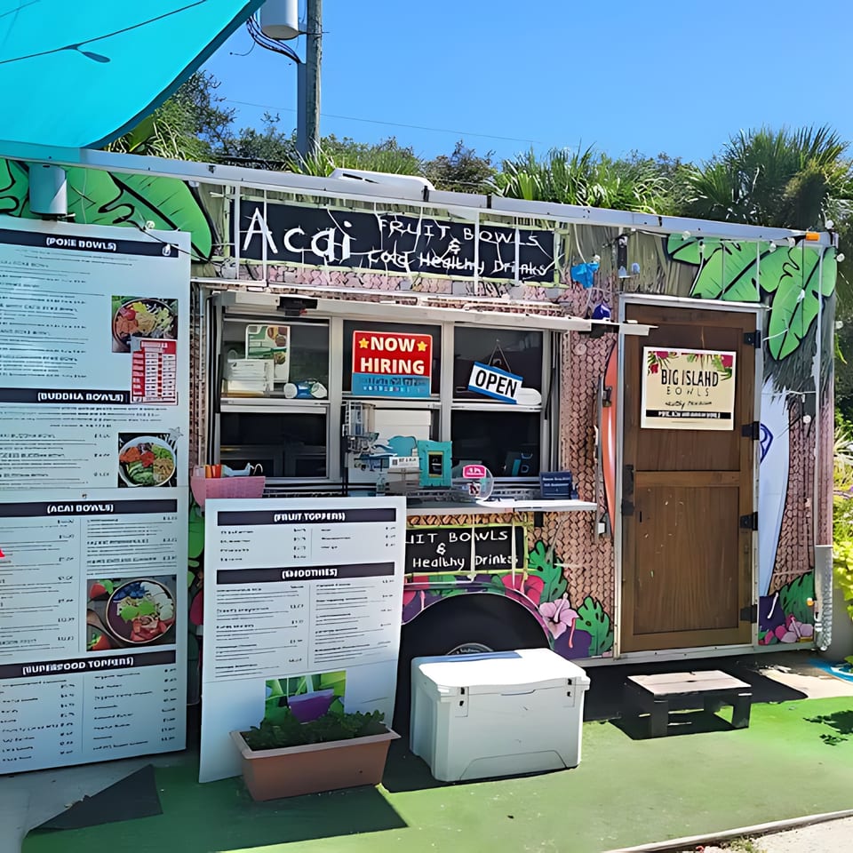 Big Island Bowls food truck with a menu, "Now Hiring" and "Open" signs, and tropical decor.