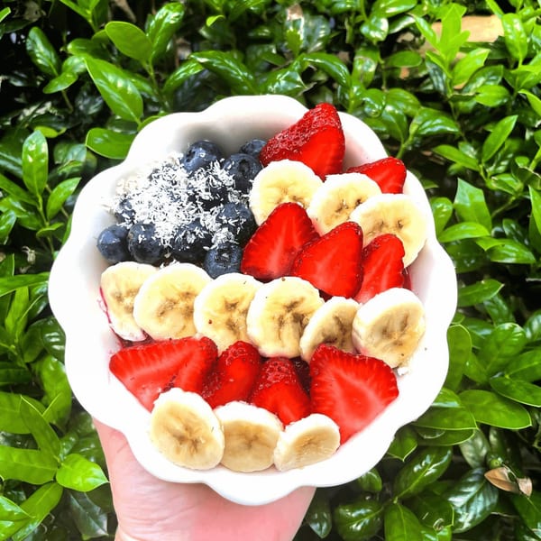 A Big Island Bowls acai bowl with blueberries, strawberries, bananas, and shredded coconut.